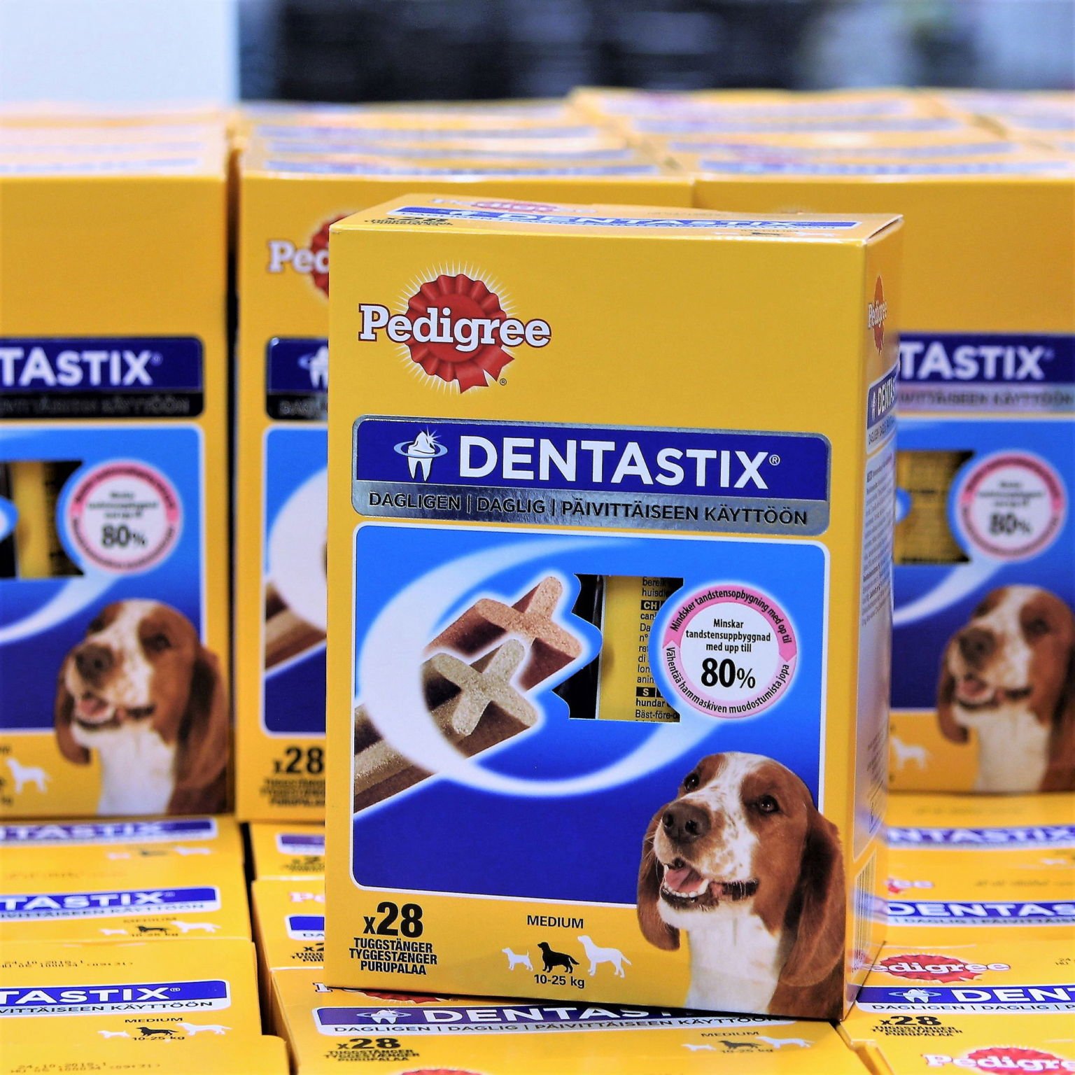 Flera paket Dentastix hundgodis, mediumstorlek, med en hund på förpackningen.