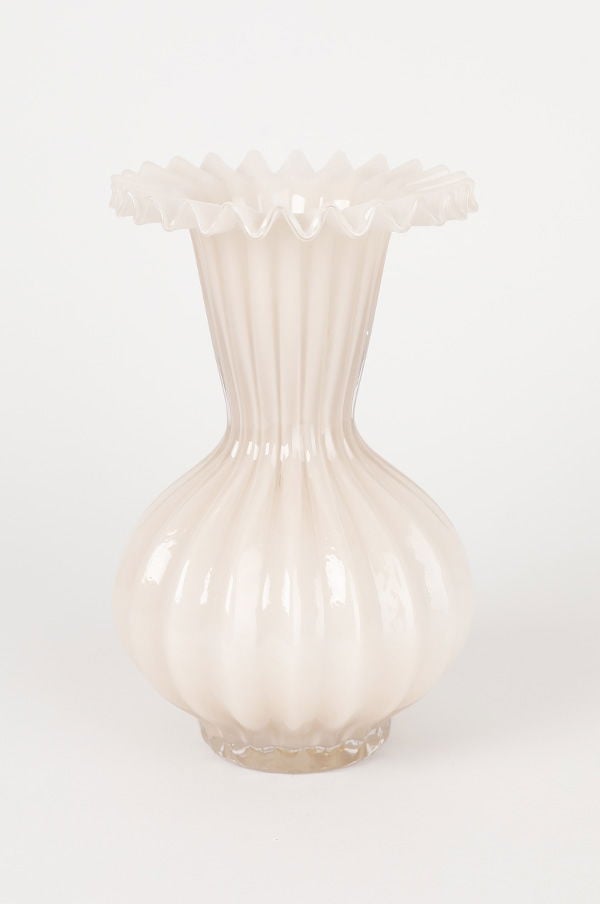 Vacker vit glasvas med vågformad kant och räfflad yta, perfekt för blommor och som dekorativt föremål.
