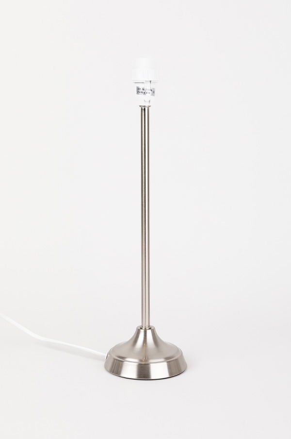 Stilren bordslampa med metallstativ och vit sockel, perfekt för modern inredning.
