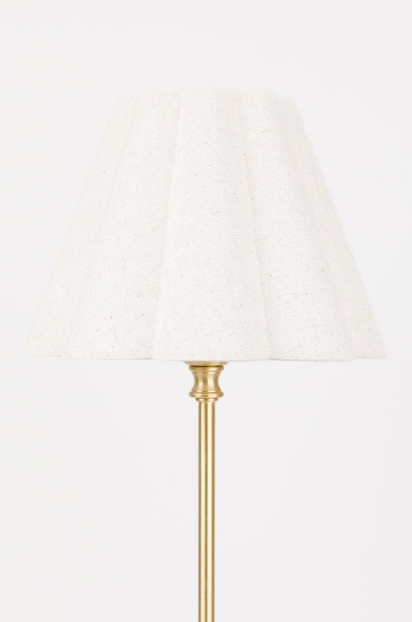 Elegant golvlampa med en vit textilskärm och en gyllene metallfot, perfekt för att skapa en varm och inbjudande atmosfär i hemmet.