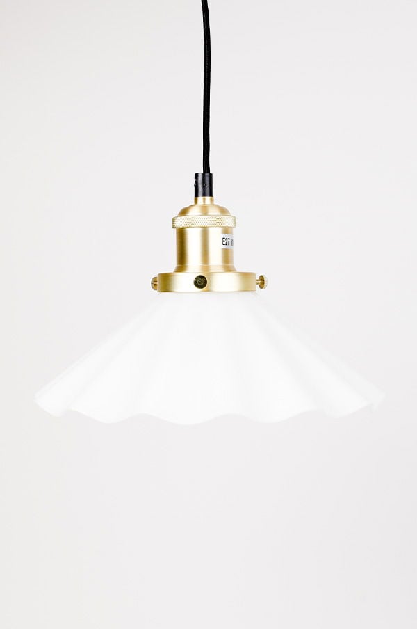Elegant vit taklampa med guldfärgad fäste och svart sladd, perfekt för att skapa en modern atmosfär i hemmet.