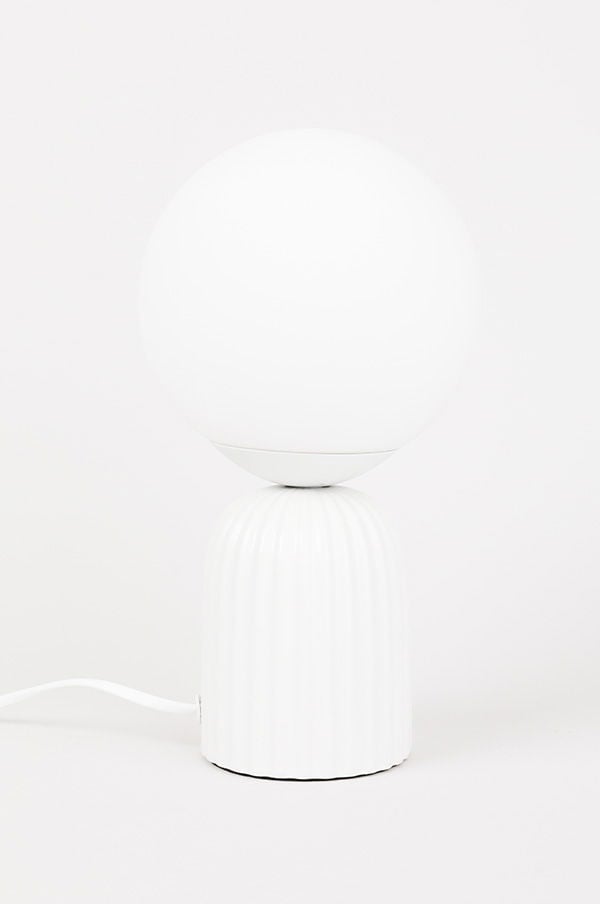 Vit bordslampa med rund skärm och strukturerad bas, perfekt för att skapa en modern och stilren atmosfär i hemmet.