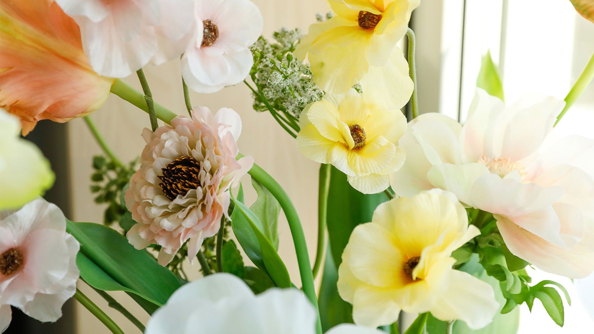 Färgglada blomsterarrangemang med rosa, gula och vita blommor i en vas, perfekt för inredning och dekoration.