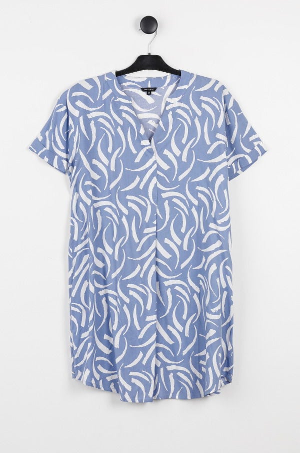 Blå klänning med vitt mönster av svepande linjer, hängande på en klädhängare. Klänningen har korta ärmar och en v-ringning, perfekt för sommarens casual stil.