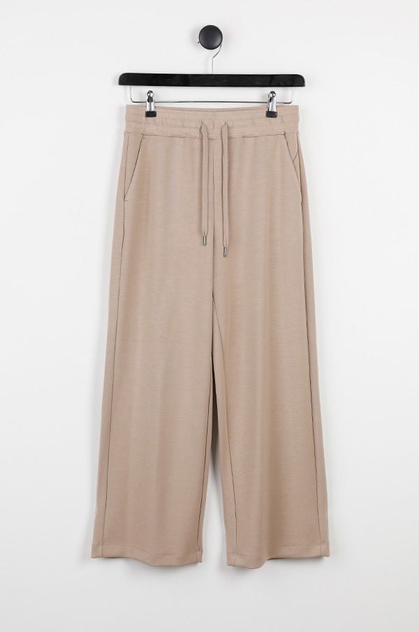 Lösa, beige byxor med midjeband och sidofickor, perfekta för avslappnade och bekväma outfits.