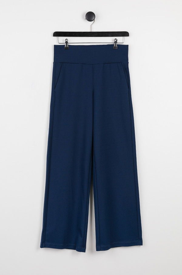 Mörkblå vida byxor med hög midja och fickor, hängande på en svart klädhängare mot en vit bakgrund. Perfekta för både avslappnade och eleganta outfits.
