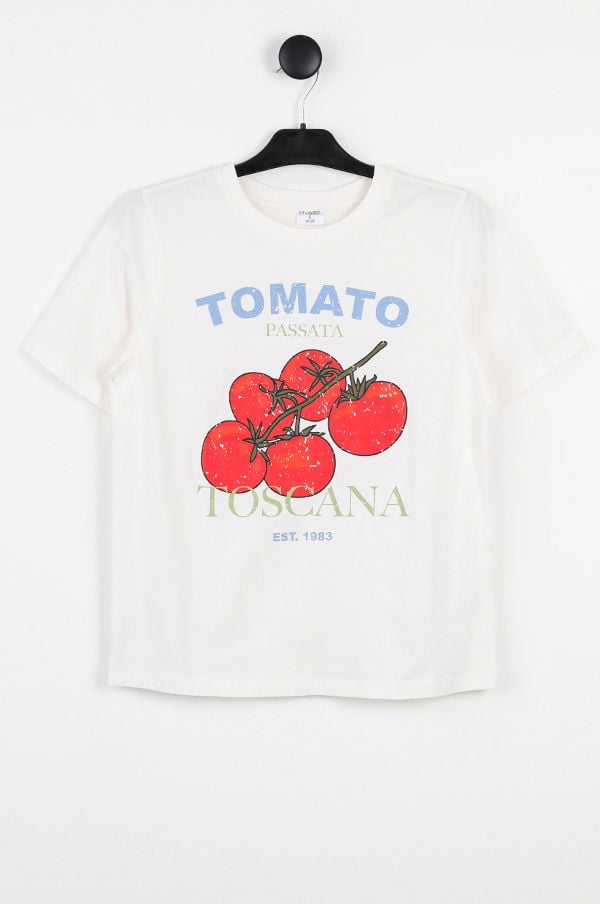 T-shirt med tomatmotiv och texten "Toscana" i färgglad design, hängande på en klädhängare.