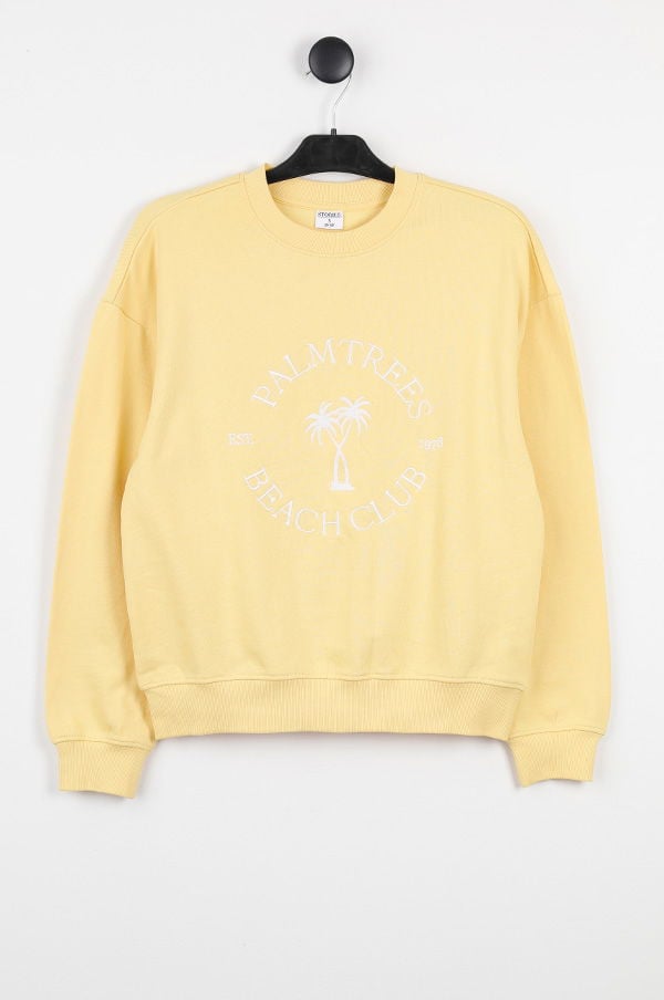 Gul sweatshirt med tryck av "Palm Trees Beach Club" och palmer, perfekt för avslappnade dagar.