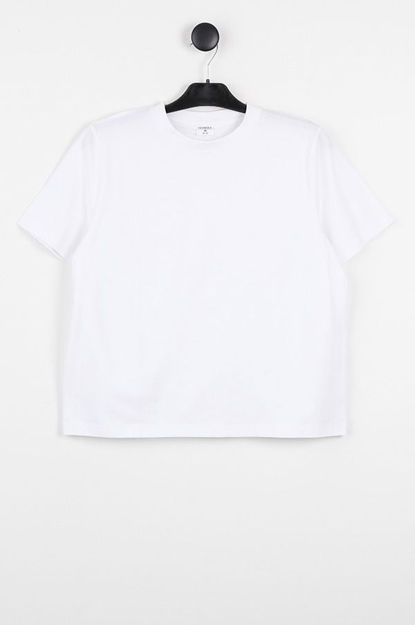 Kortärmad vit t-shirt hängande på en svart klädhängare mot en neutral bakgrund, perfekt för en avslappnad stil eller som basplagg i garderoben.
