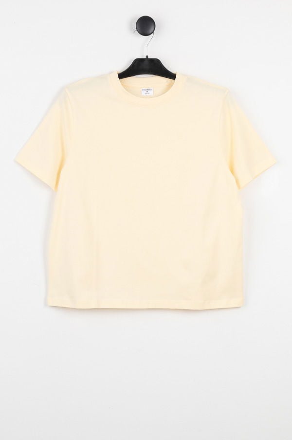 Kortärmad t-shirt i ljusgul färg, hängande på en svart klädhängare mot vit bakgrund. Perfekt för avslappnade outfits och sommarbruk.