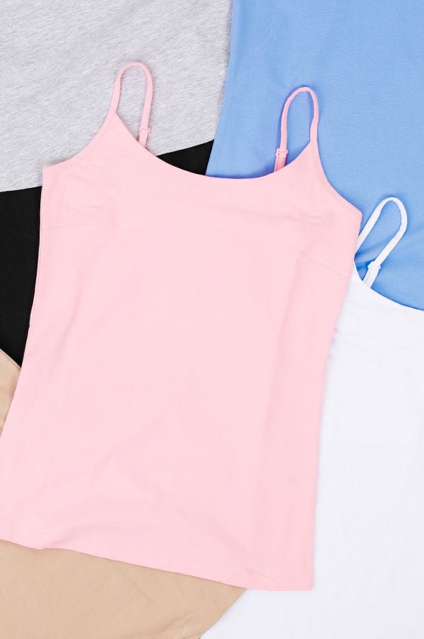 Flera linnen i olika färger, inklusive rosa, grått, blått och vitt, som ligger över varandra på en vit bakgrund. Perfekta för lager-på-lager-styling eller som basplagg för olika outfits.