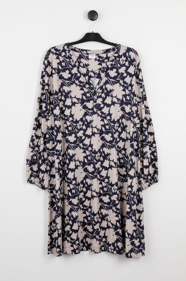 Mörkblå klänning med blommönster och långa ärmar, hängande på en klädhängare mot en vit bakgrund. Perfekt för vår- och sommaroutfits.