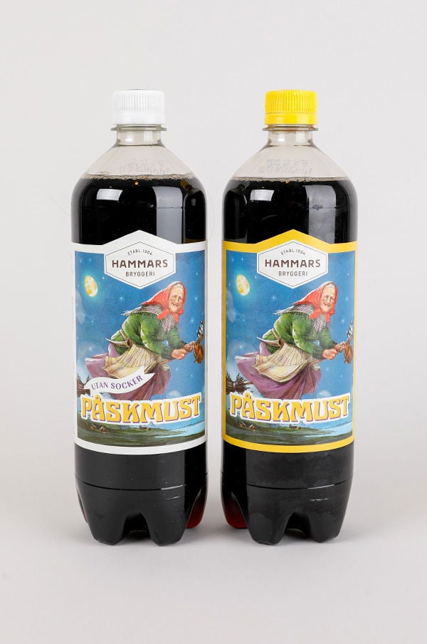 Två flaskor med PÅSKmust från Hammars Bryggeri, en med socker och en utan socker, båda med färgglad etikett och illustration av en påskkärring.