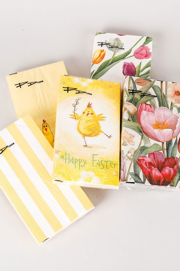 Flera påskkort med färgglada motiv, inklusive en glad kyckling och blommor, på en ljus bakgrund.