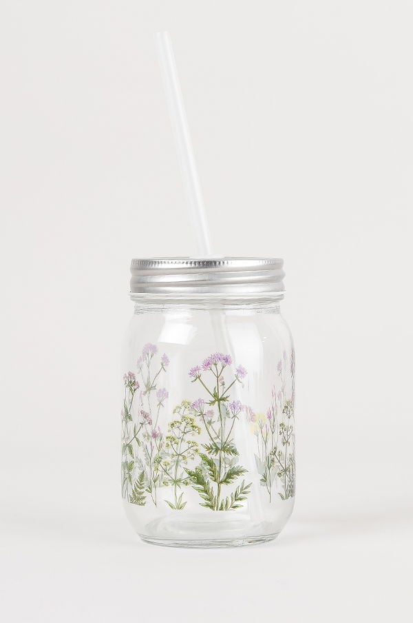 Glasburk med blommönster och sugrör, perfekt för kalla drycker och som dekorativt inslag i hemmet.