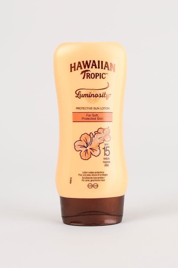 Hawaiian Tropic Luminosity solkräm i flaska med SPF 15, designad för att skydda och mjukgöra huden.