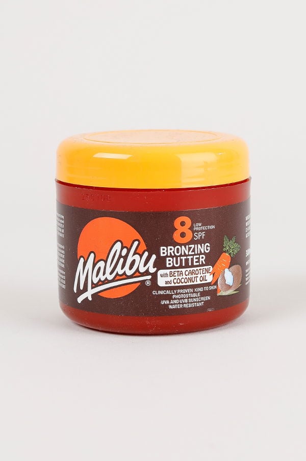 Malibu bronzing butter med SPF 8 i en röd burk, berikad med beta-karoten och kokosolja, som ger låg solskydd och är vattenresistent.