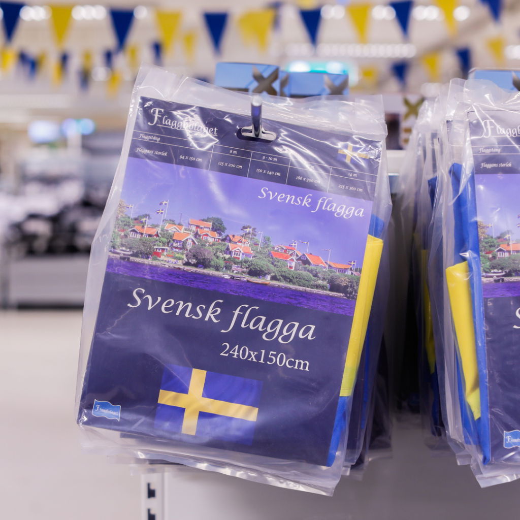 Svensk flagga i plastförpackning, mått 240x150 cm, med blå och gul design, tillgänglig i butik.