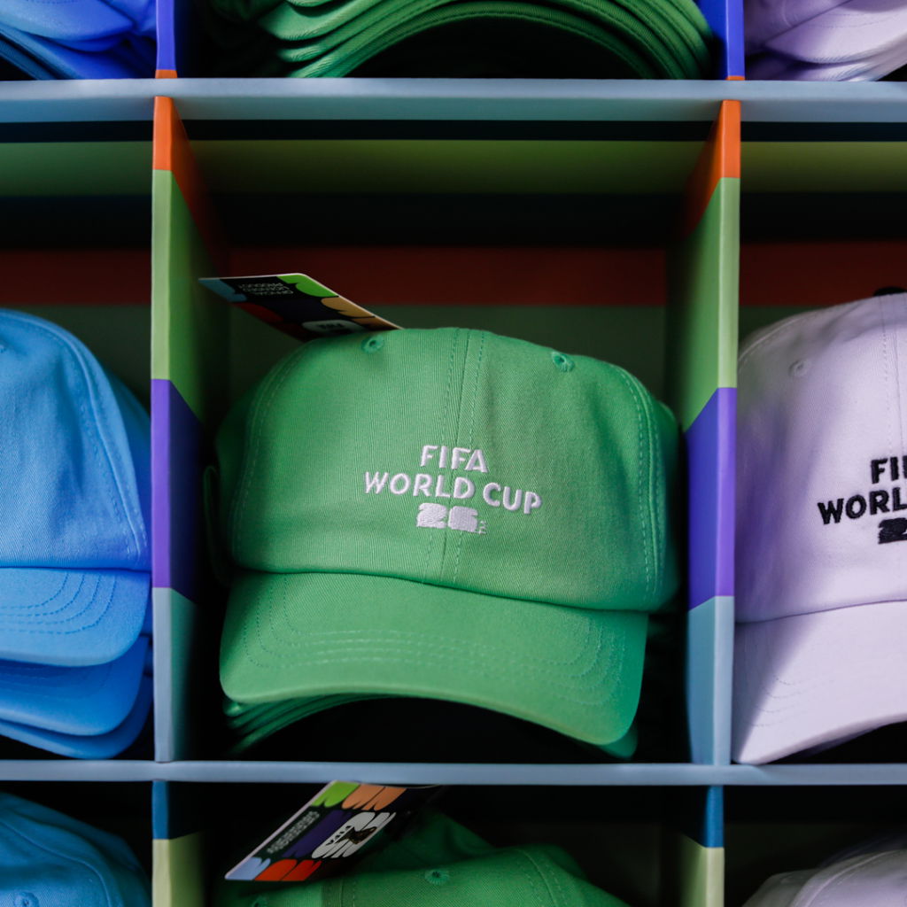 Gröna kepsar med FIFA World Cup 2022-logotyp som visas i en färgglad hylla.