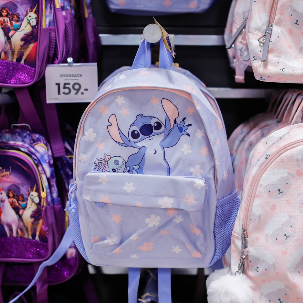 Lila ryggsäck med Stitch-motiv och blommor, perfekt för barn. Finns till försäljning för 159 kronor.