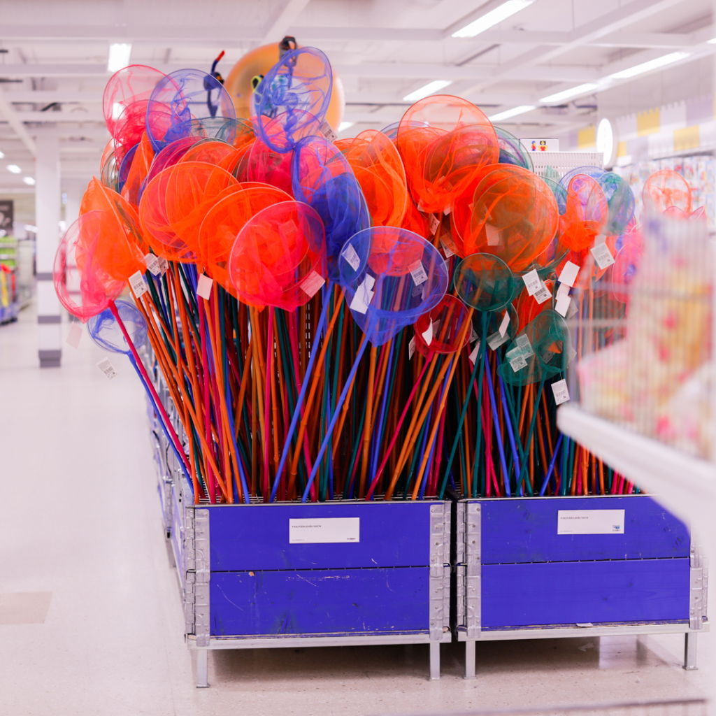 Färgglada insektsnät i en butik, staplade i en låda med blått. Perfekta för barnens utomhusaktiviteter och lek.