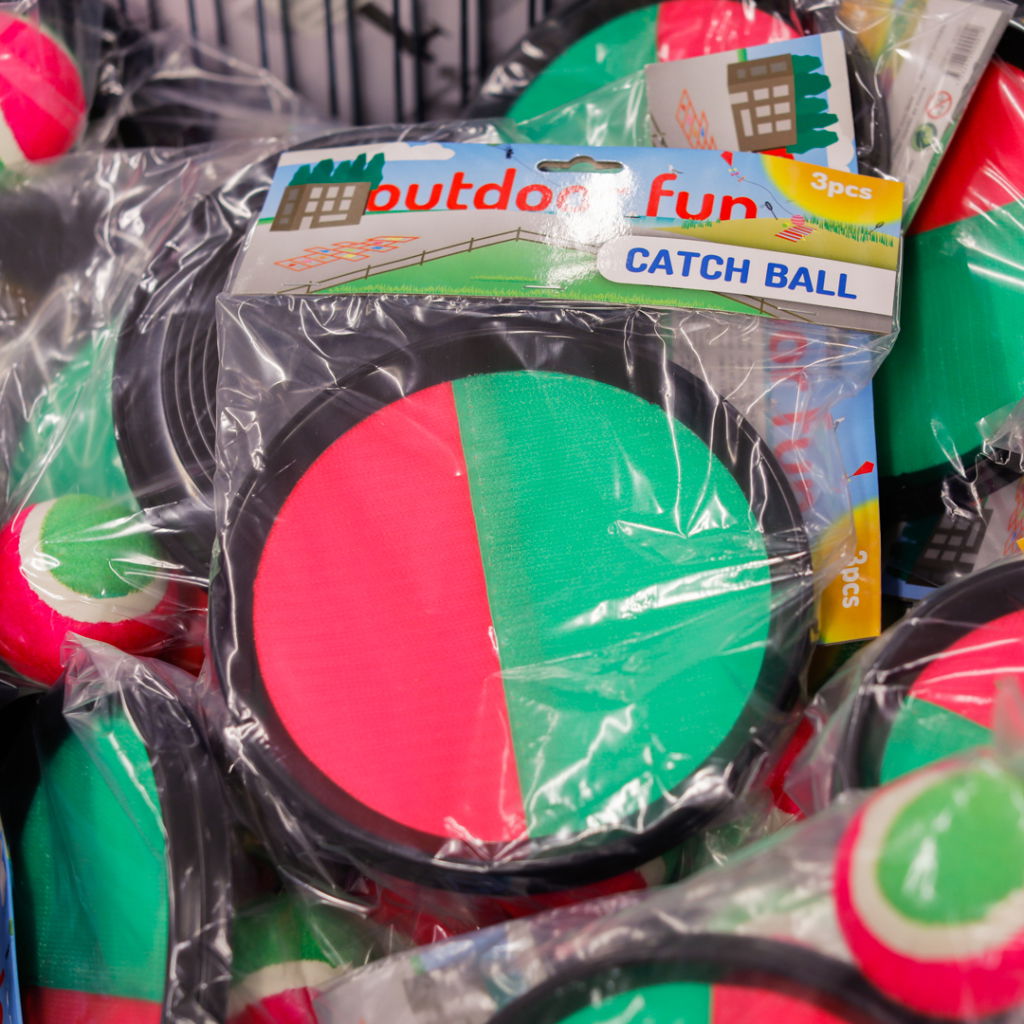 Färgglada fångbollar i plastförpackning, perfekt för utomhuslek. Setet innehåller tre bollar med svart kant och två färger, röd och grön, som gör dem lätt synliga.