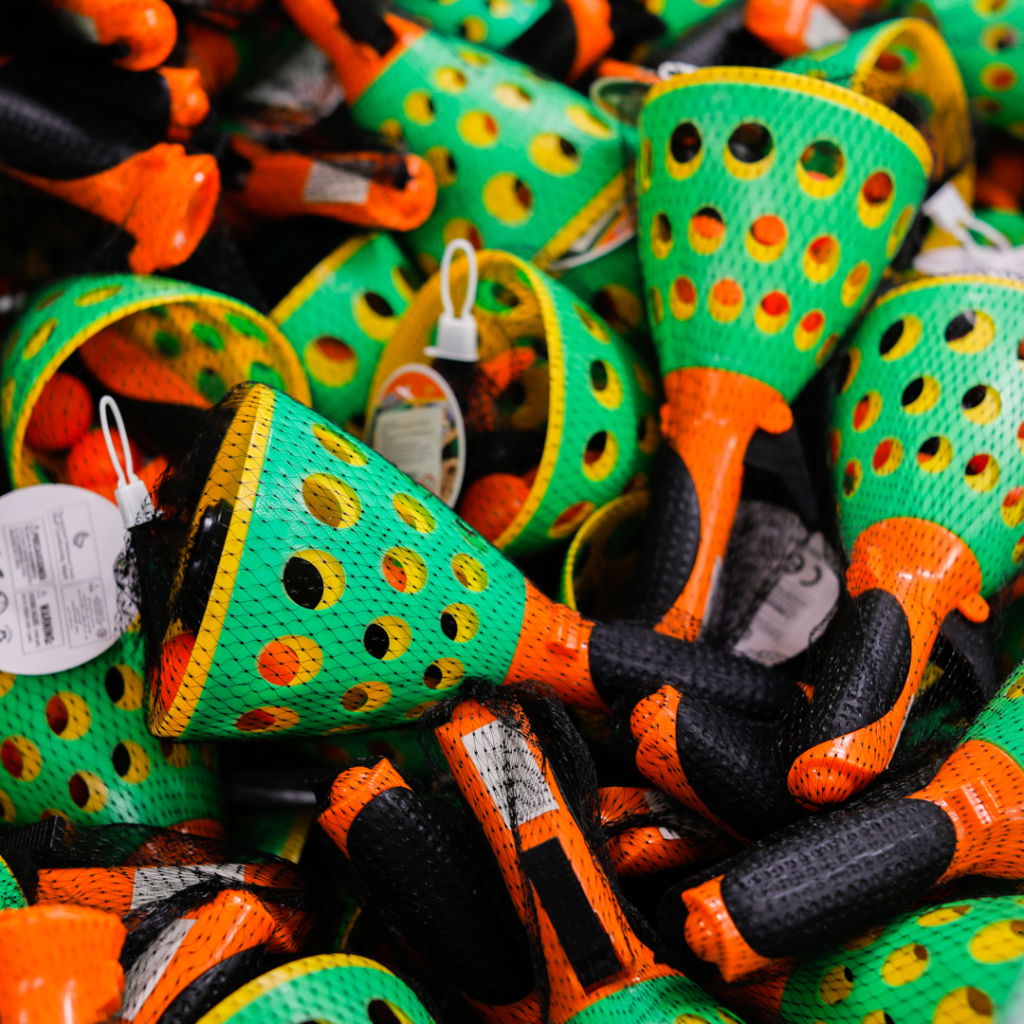 Färgglada fiskekrokar i grönt och orange, staplade i en bunt med detaljerade nät.