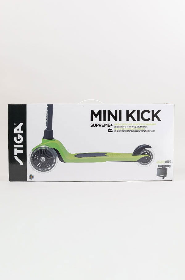 Grön Mini Kick Supreme+ sparkcykel från Stiga, förpackad i en vit kartong med tydlig produktinformation och logotyp.