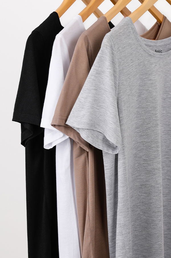 Fyra t-shirts i olika färger hängande på en klädhängare, inklusive svart, vitt, beige och grått, med fokus på enkel och stilren design.