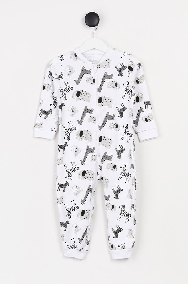 Vit pyjamas med djurmönster för barn, designad med tryck av zebror och andra djur. Perfekt för komfort och stil under natten. Hängande på en klädhängare mot en vit bakgrund.