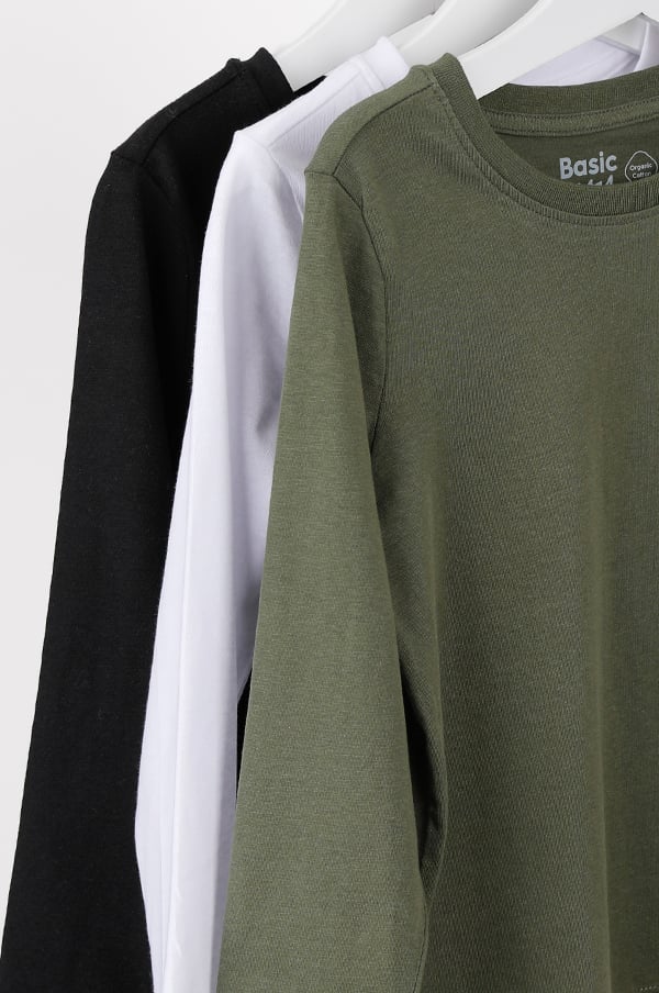 Tre t-shirts i svart, vitt och olivgrönt hängande på en klädhängare, märkta med "Basic". Perfekta för en avslappnad stil.