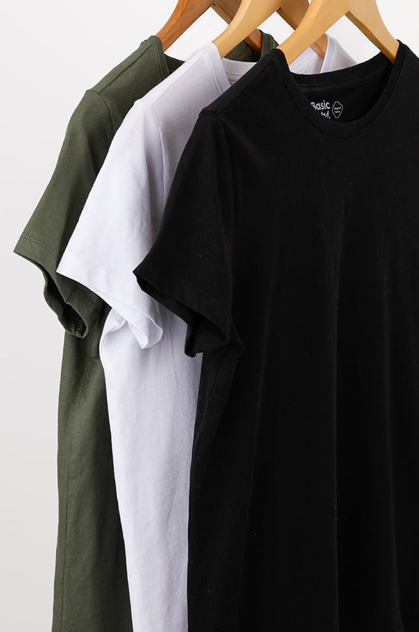 Tre t-shirts i olika färger (svart, vit och grön) hänger på klädhängare, perfekt för en avslappnad stil.
