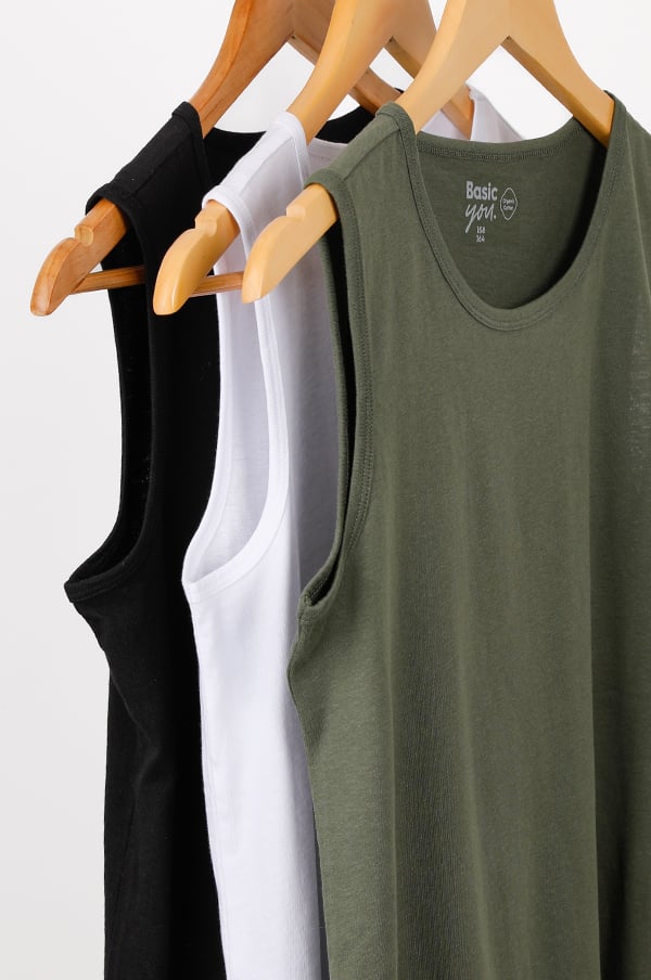 Tre ärmlösa t-shirts i svart, vitt och olivgrön hänger på klädhängare, perfekt för en avslappnad stil eller som basplagg i garderoben.