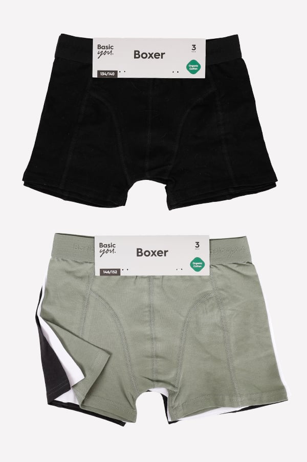 Svart och grön boxerkalsonger i ekologisk bomull, storlekar 134/140 och 146/152, med etiketter som visar produktinformation.