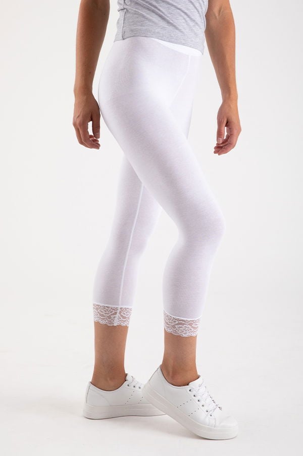 Vit leggings med spetsdetalj, perfekt för både träning och avslappning, stylat med en grå t-shirt och vita sneakers.