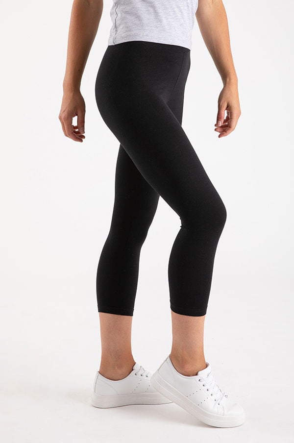 Svart leggings för kvinnor i en avslappnad stil, perfekt för träning eller vardagsbruk, kombinerat med vita sneakers.
