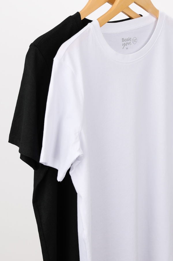 Två t-shirts i svart och vitt hängande på en trägalge, designade för komfort och stil. Perfekta basplagg för alla garderober.