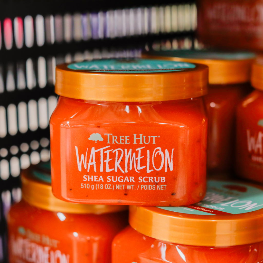 Burk med Tree Hut Watermelon shea sugar scrub, 510 g, i en hylla. Produktens etikett visar en livlig design med vattenmelonmotiv och texten "Watermelon Shea Sugar Scrub".