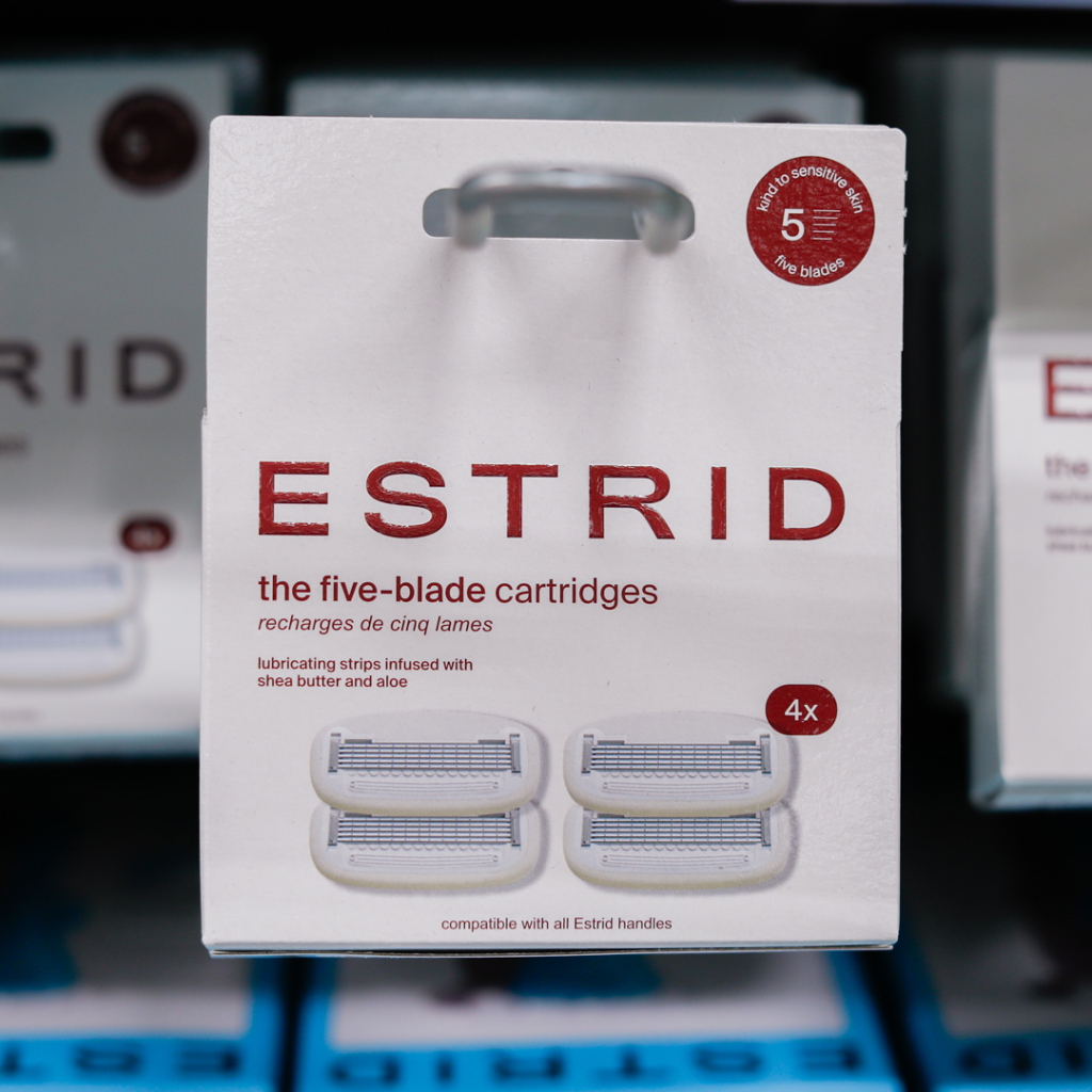 Förpackning med ESTRID fembladsrakbladskassetter, inklusive fyra kassetter med smörjande remsor berikade med sheasmör och aloe vera, kompatibla med alla ESTRID-handtag.