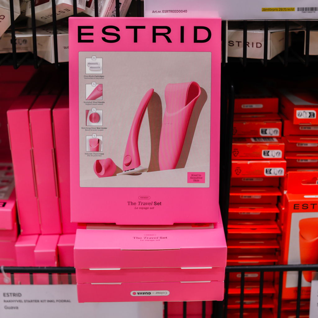 Bild på ESTRIDs resekit för hårborttagning, som inkluderar en rakapparat med ett ergonomiskt handtag och en skyddande reseförpackning. Produkten är utformad för känslig hud och kommer i en iögonfallande rosa förpackning.