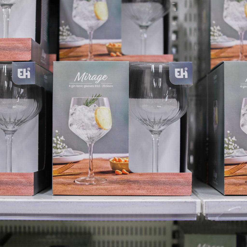Förpackning med fyra gin och tonic glas i Mirage-design, varje glas rymmer 61 cl. Glasen är placerade på en hylla i en butik och visar en stilren presentation med is, citron och dekoration.