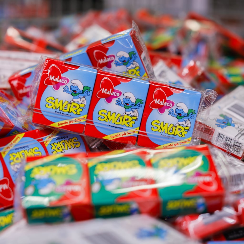 Malaco Smurf godisförpackningar staplade i en färgglad hög. Produkten är känd för sin fruktiga smak och är populär bland både barn och vuxna.