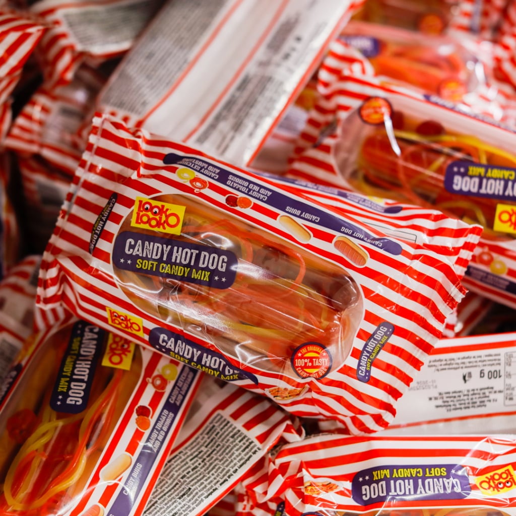 Kreativ förpackning av Candy Hot Dog, en mjuk godismix med färgglada godisar, staplade i ett litet parti.