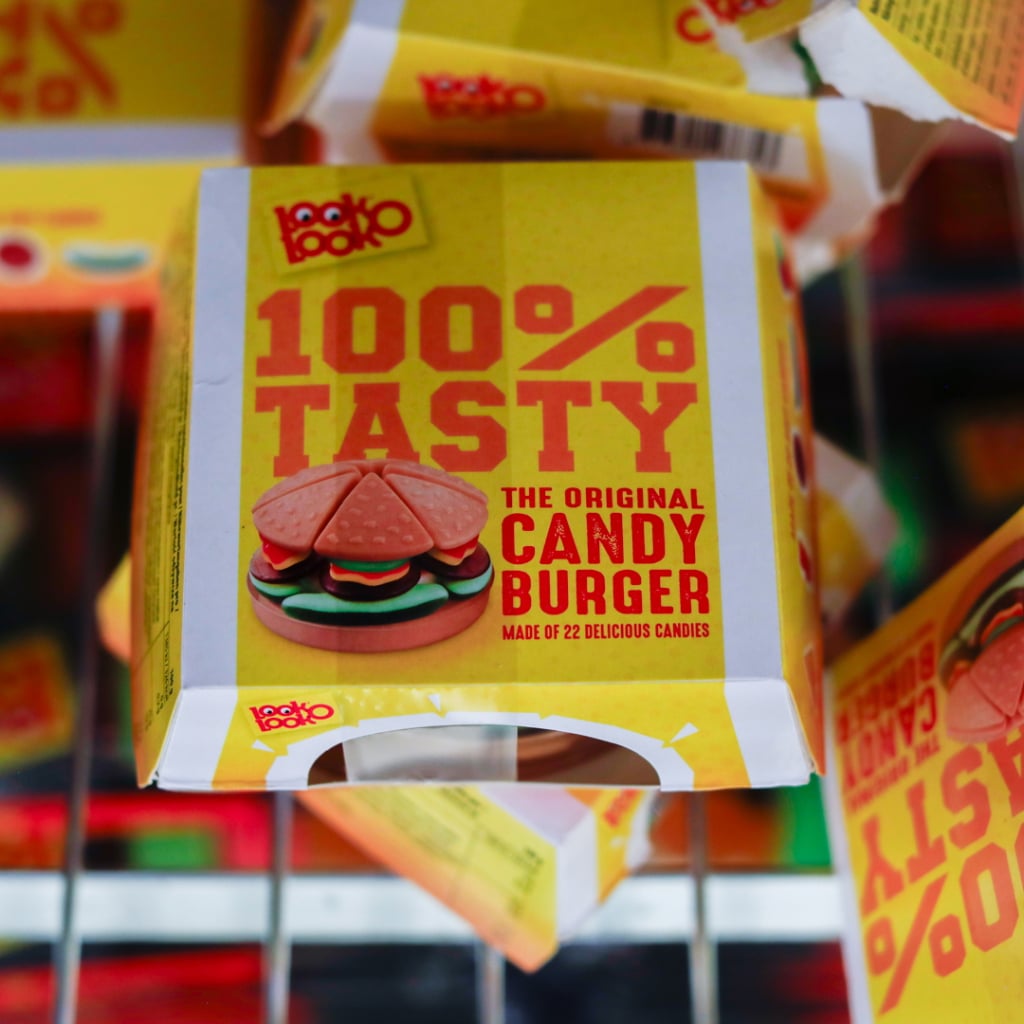 Förpackning av godisburgare med texten "100% Tasty" och "The Original Candy Burger", tillverkad av 22 läckra godisar.