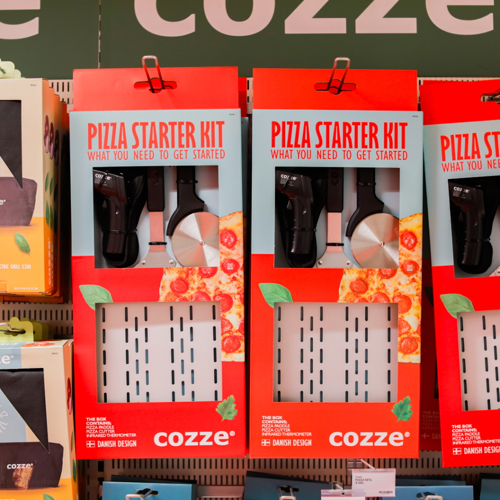 Produktbild av ett pizza-startpaket från Cozze, med en pizzaskärare och en termometer, designad för att underlätta hemmagjord pizza.