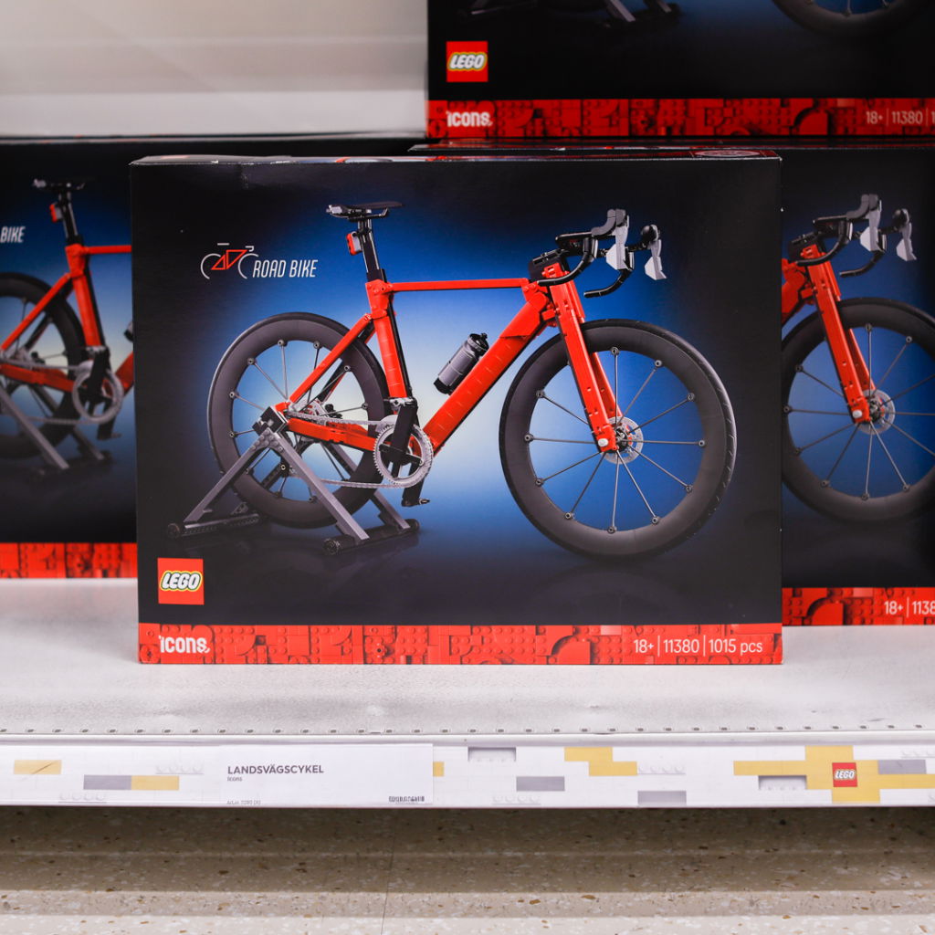 LEGO Icons landsvägscykel, modell 11380, med 1015 delar, visad i butik. Cykeln är i en iögonfallande röd färg och står på en ställning.