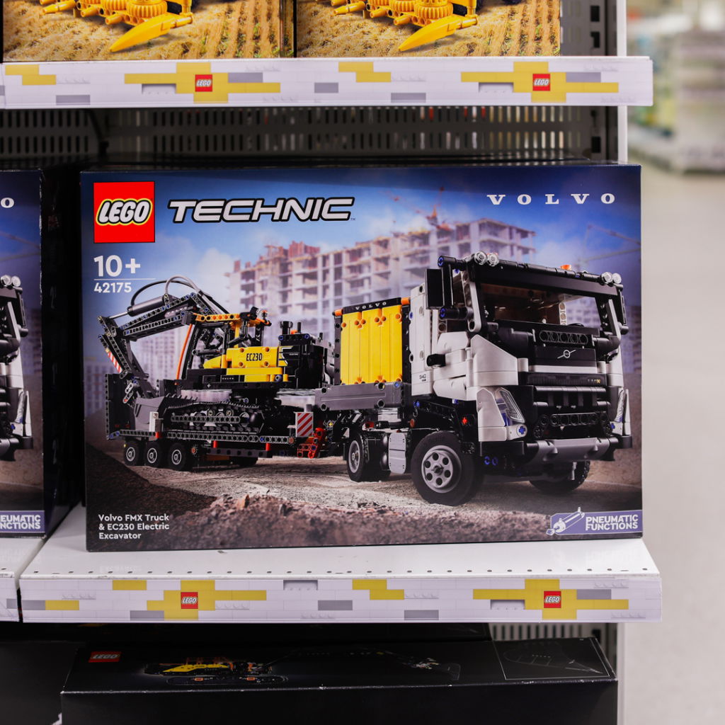 LEGO Technic set 42175 med Volvo FMX-lastbil och EC230 elektrisk grävmaskin, designad för barn över 10 år, visas på butikshylla.