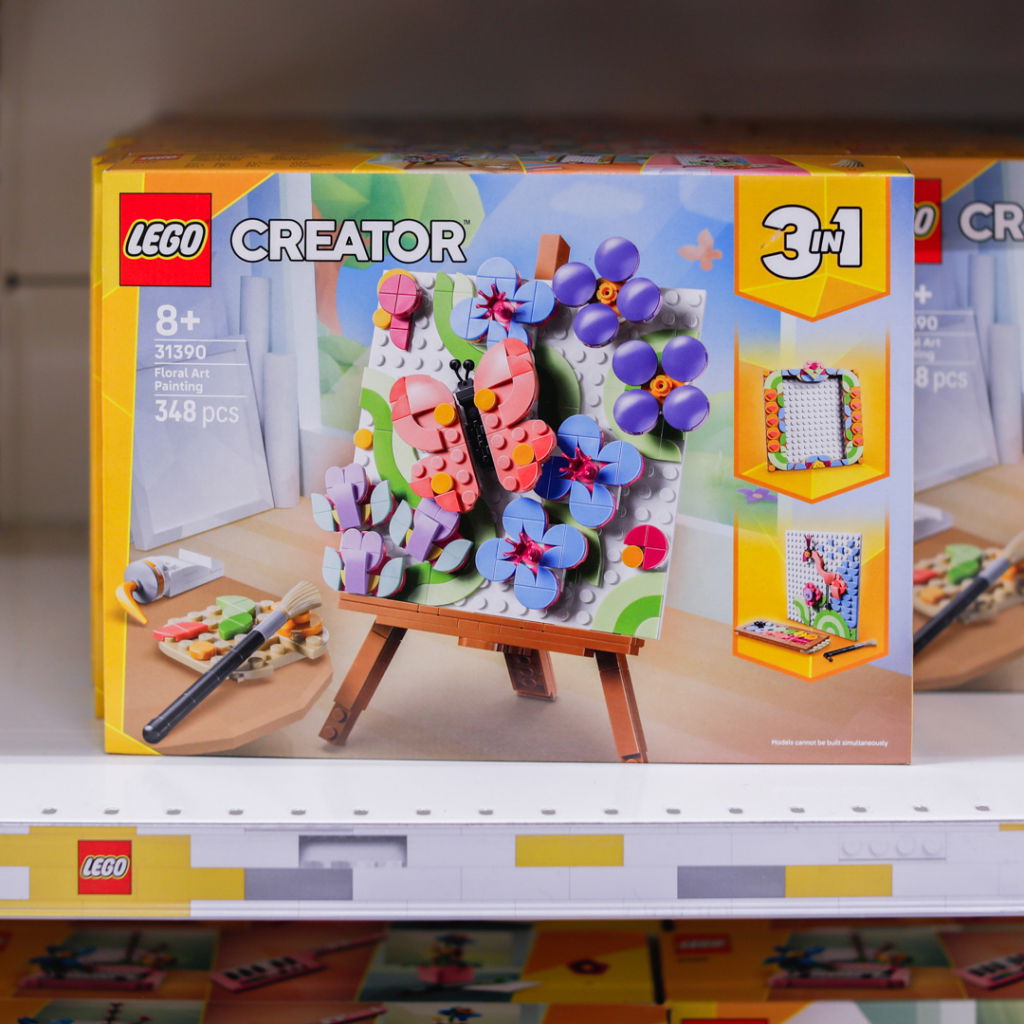 LEGO Creator set 31390 med blommotiv, innehållande 348 delar för åldrar 8 år och uppåt. Setet inkluderar en målarduk på ett staffli och en pensel, med möjlighet att bygga tre olika blommotiv.